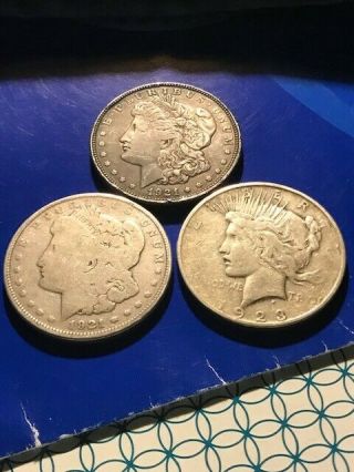 Two 1921 P Morgan Silver Dollars,  One 1923 - D Peace Dollar.  01 Start
