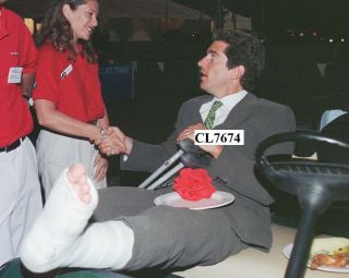 John F.  Kennedy Jr.  Sits With His Leg In A Cast In Golf Cart At Auto Race Photo
